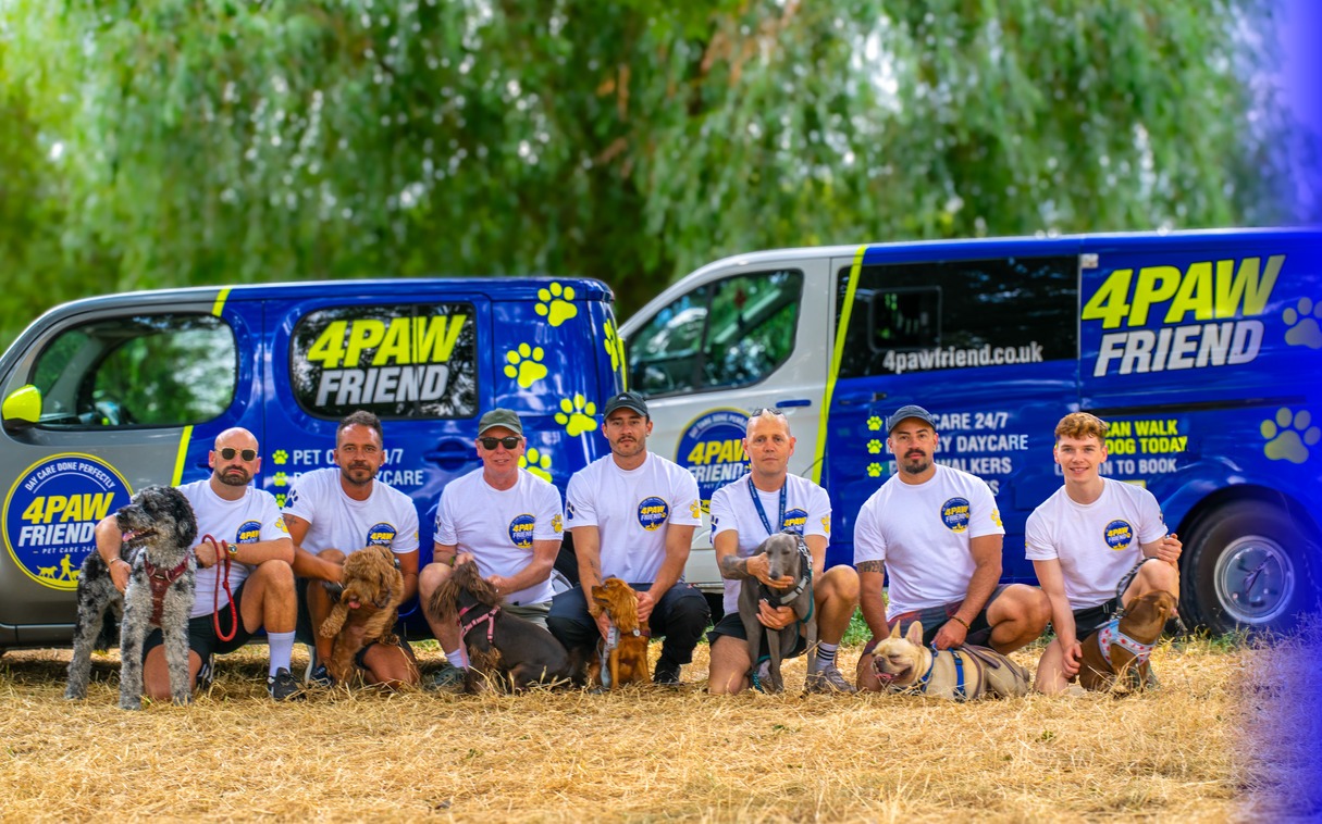 The 4 Paw Friend dog walking team with dogs and branded vans in South London