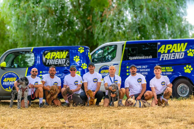 The branded 4 Paw Friend pet taxi vans with the team and their dogs.