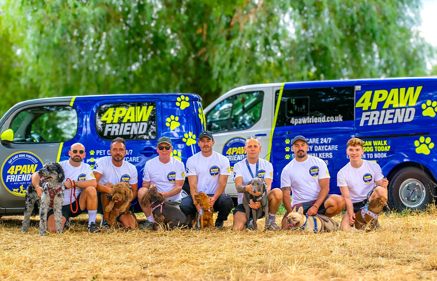 The 4 Paw Friend team with their dogs in front of the branded vans in South London.