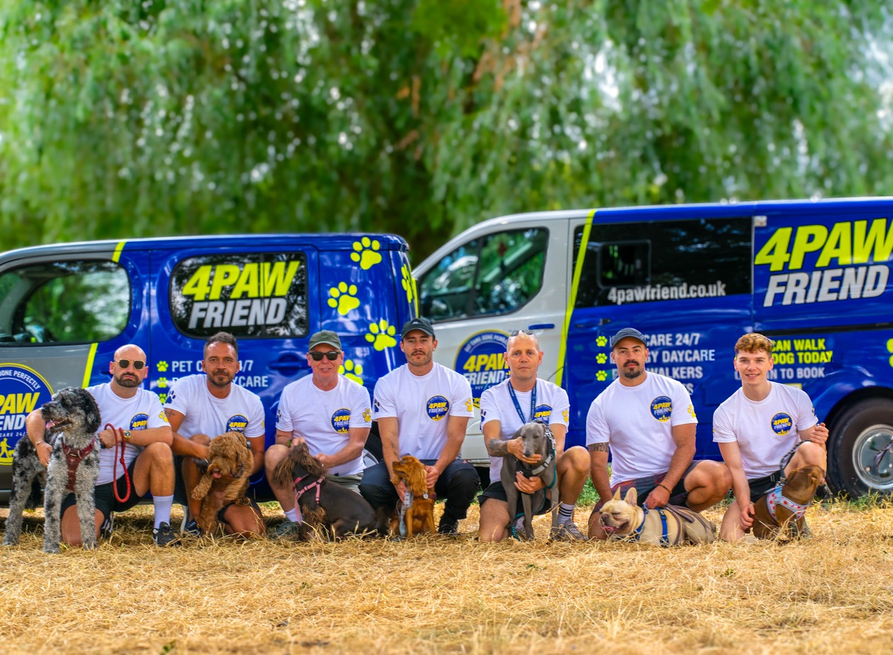 The 4 Paw Friend team with their dogs in front of the branded vans in South London.